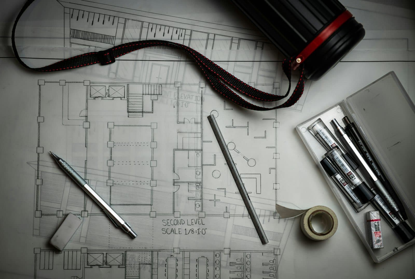 Planos y herramientas de dibujo sobre un escritorio de trabajo