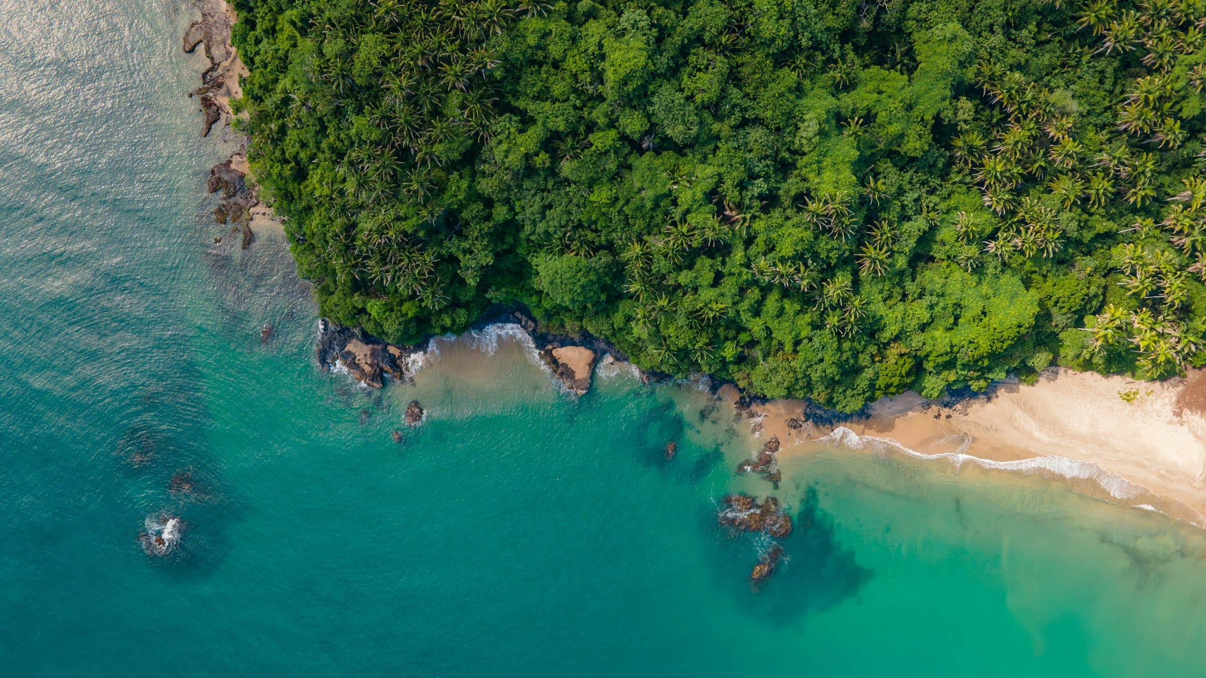 Cala de agua turquesa al pie de un cerro cubierto de selva en la costa de Jalisco